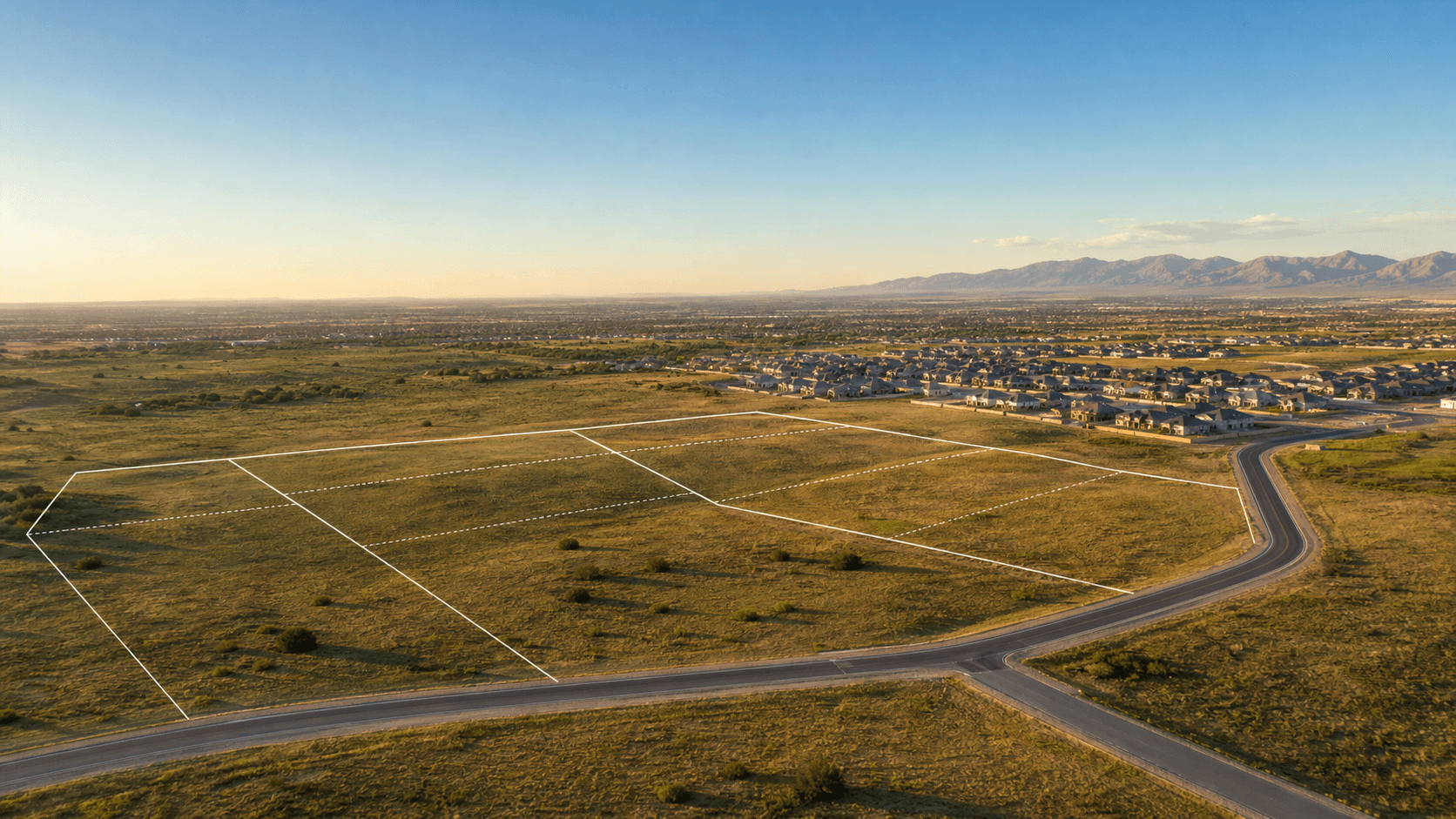 Aerial view of vacant land parcels near new residential development